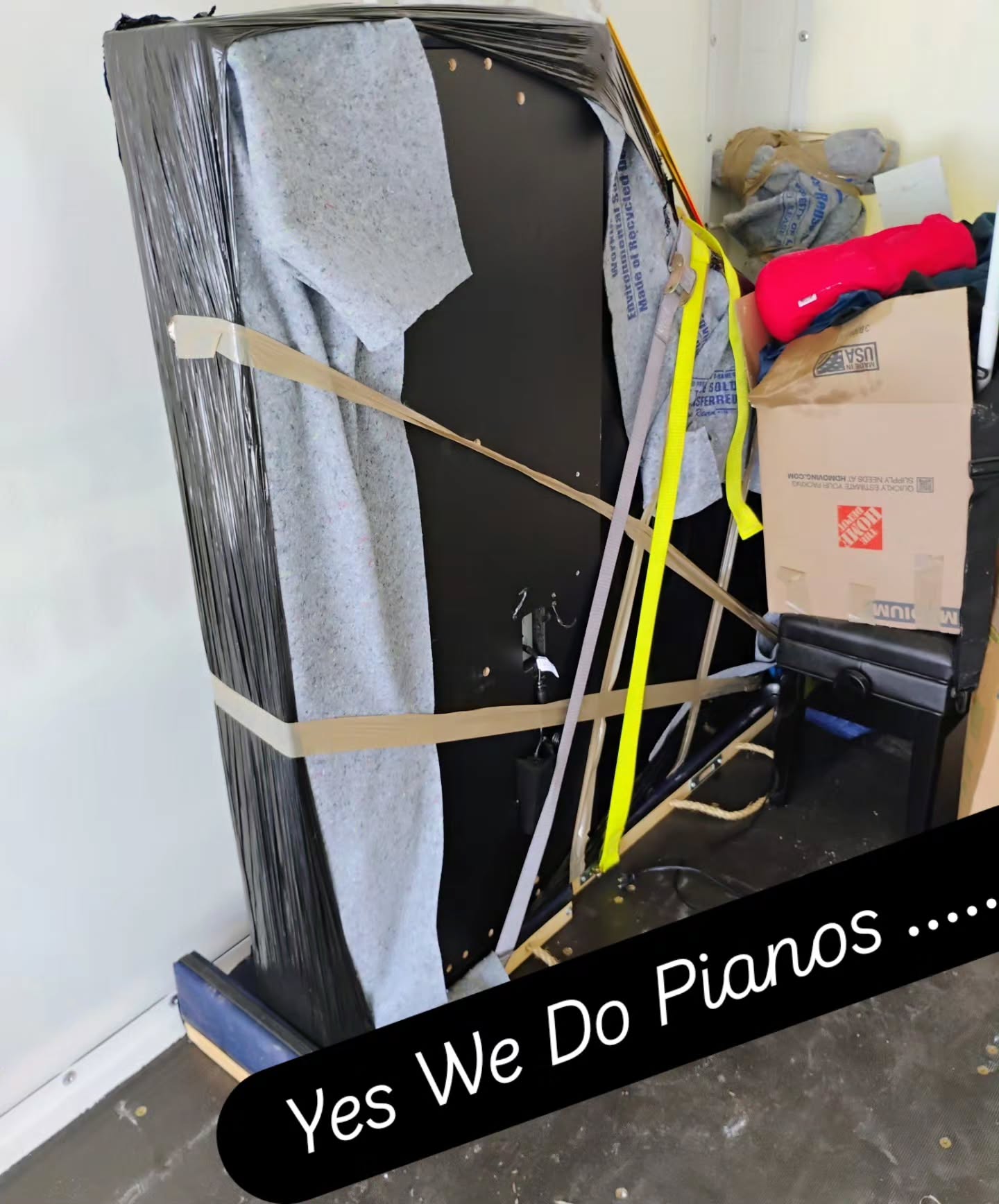 Upright piano wrapped and secured for moving by Perfect Touch Moving